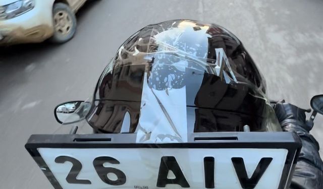 Düşen plakasını kaskına bantlayıp yoluna devam etti